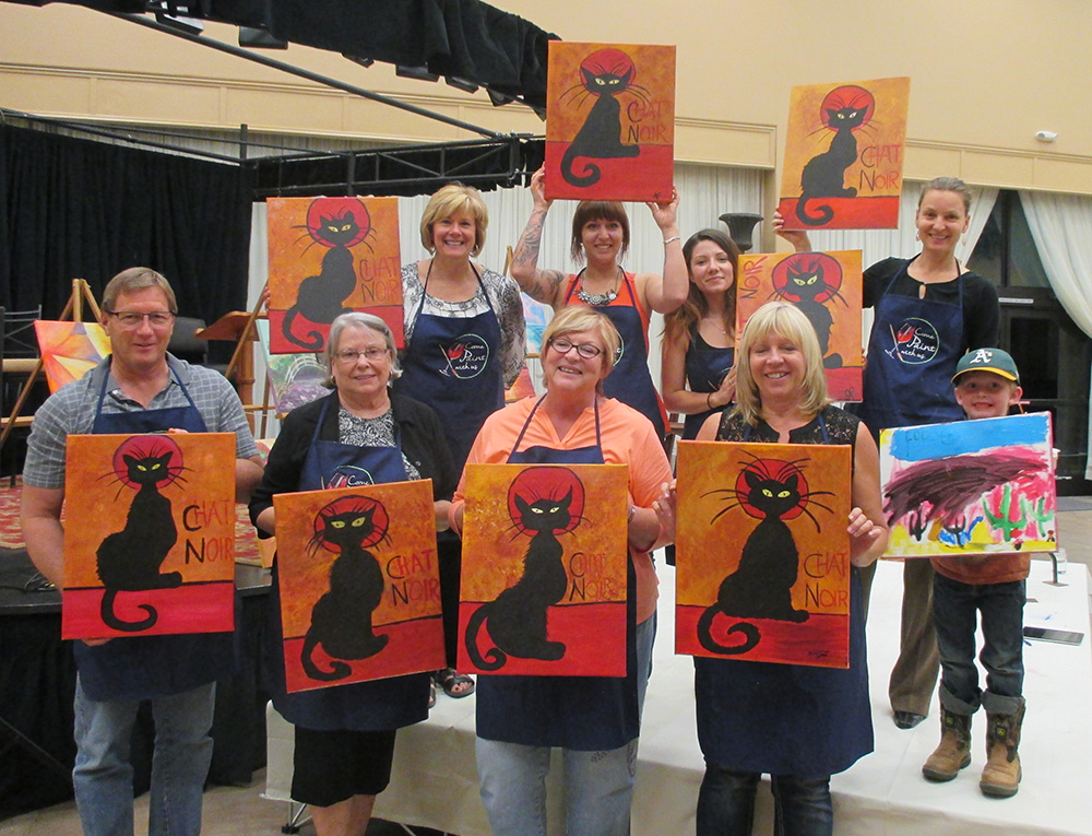 Happy customers show off paintings
