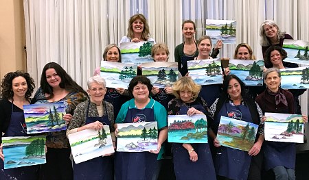 A group of happy painters show off their creations