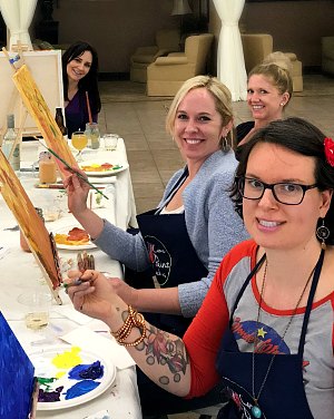 A few moms pose for a photo during paint class